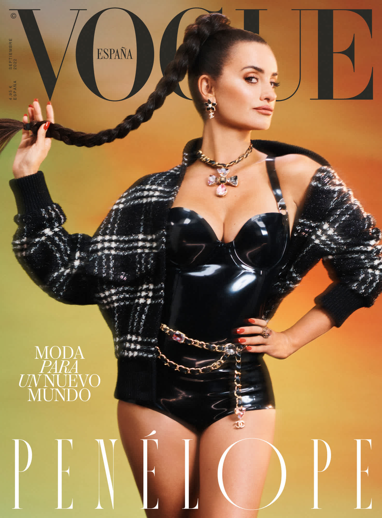 Cover of Vogue Spain with Penelope Cruz. She is standing with her arm on her hip, and holding up her long braid with the other hand. She is wearing a reflective black body suit, black and white checkered jacket, Chanel accessories, and is standing in front of a backdrop that goes from green to orange.