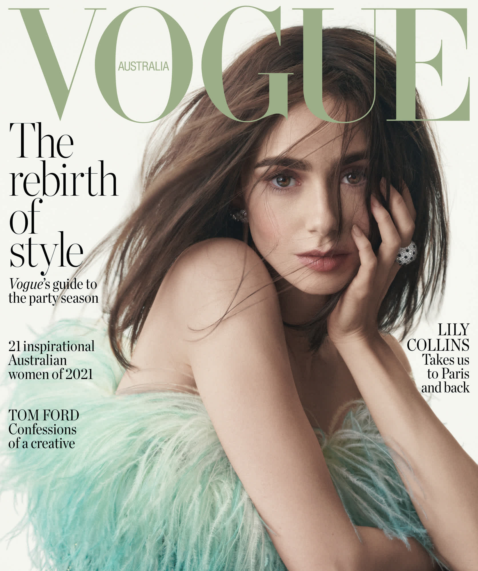 Cover of Vogue Australia with Lily Collins. She is wearing a frilly blue and green shoulder less dress. She is holding her face with one hand and looking at the camera.
