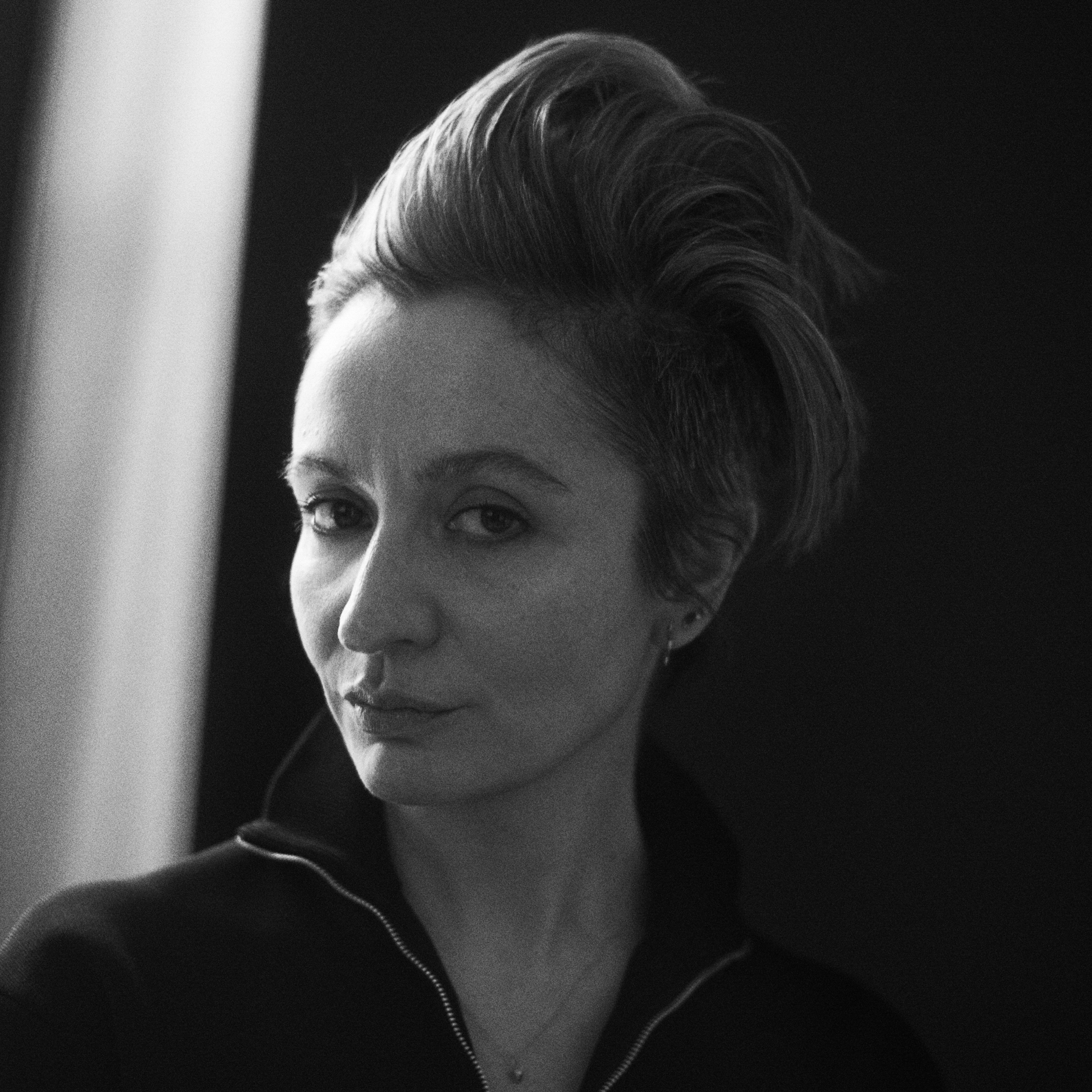 Portrait of Veronica Leoni with her head angled and looking directly at the camera. 