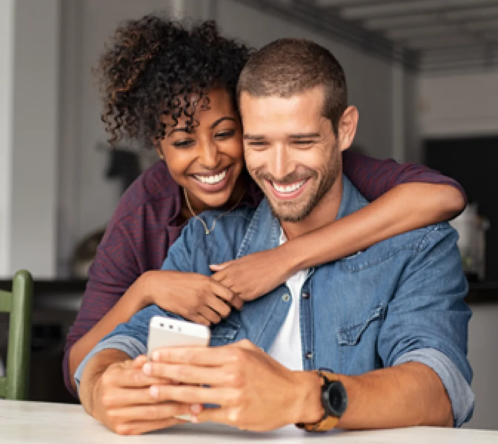 woman embracing a man looking at a phone