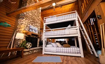 White Queen Triple Bunk Bed for adults in a high end cabin seen from a low angle at the left-hand corner of the bed.