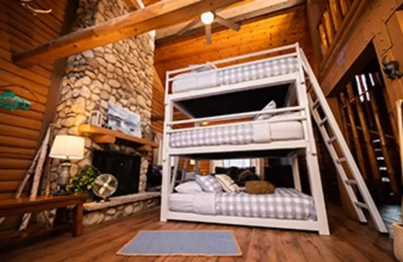 White Queen Triple Bunk Bed for adults in a high end cabin seen from a low angle at the left-hand corner of the bed.