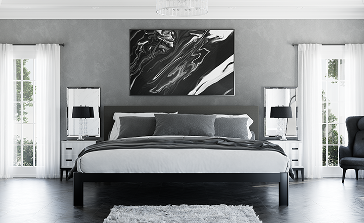 Black Alaskan King Bed in a high-end luxury bedroom with mostly gray and black and white decor seen directly from the foot of the bed.