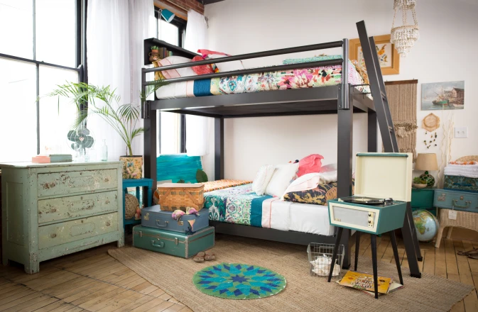 A charcoal Queen Over Queen Adult Bunk Bed in a decorated bedroom shared by two adult female roommates. Interior design.