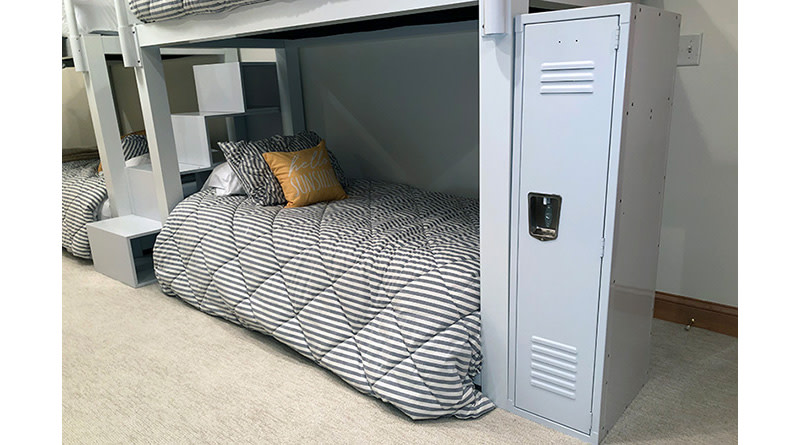 A white locker sitting next to a white Twin Over Twin Bunk Bed with stairs.