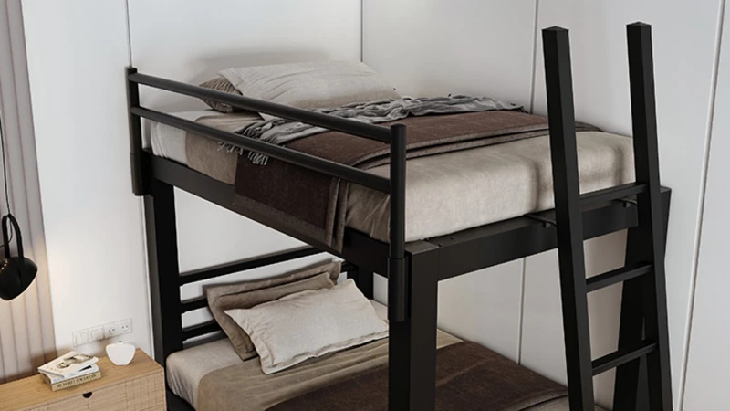 High-angle semi-close up of a black Adult Bunk Bed top bunk with ladder seen from lower right-hand corner of the bed frame.