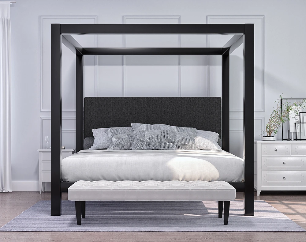 A black Wyoming King size metal four poster canopy bed with a dark headboard in a light, airy room decorated in a bright minimalist style. See directly from the foot of the bed.