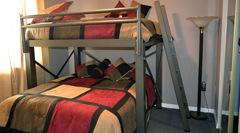 A charcoal L-Shaped Bunk Bed (Adult Loft Bed frame over a Platform Bed frame) in a customer's guest bedroom.