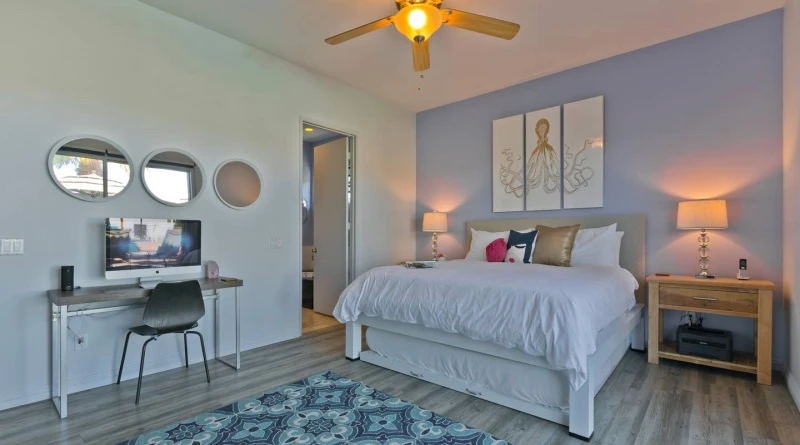 A white King Size Standard Bed in a vacation rental in the Coachella Valley, Southern California. It has a matching trundle accessory. 