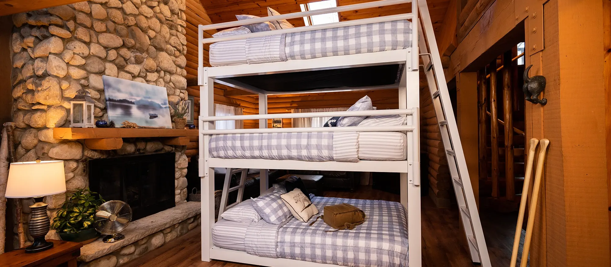 White Queen Triple Bunk Bed in a Cabin seen from a wide angle at the left-hand side of the bed.