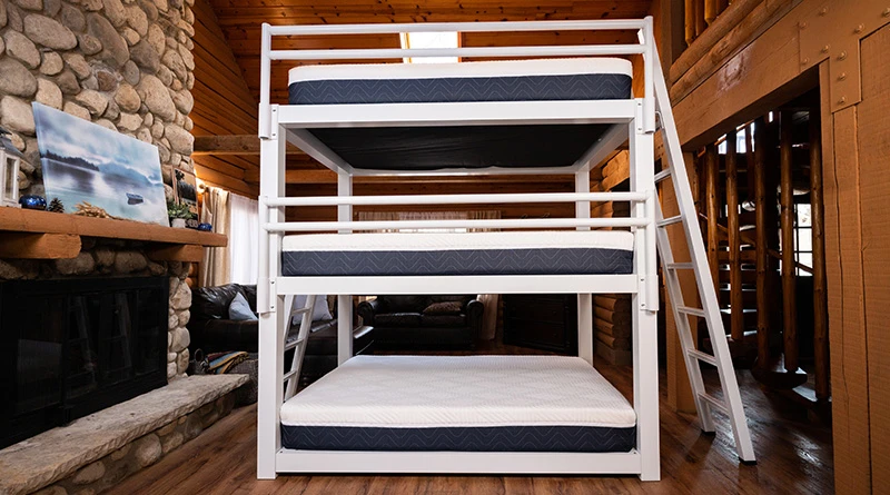 A white queen size metal Triple Bunk Bed for adults with undressed Francis Lofts and Bunks memory foam mattresses on each bunk.
