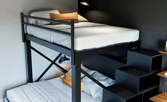 A black Full Over Queen L-Shaped Bunk Bed for adults with a matching staircase in a high end guest room. Seen at a slight close-up from the lower right-hand side of the top bunk.
