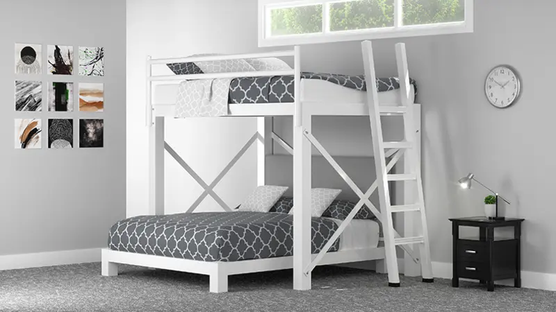 A white Full Over Queen L-Shaped Bunk Bed with light gray bedding in a basement guest room with gray walls. Seen from the bottom right corner of the bottom bunk.
