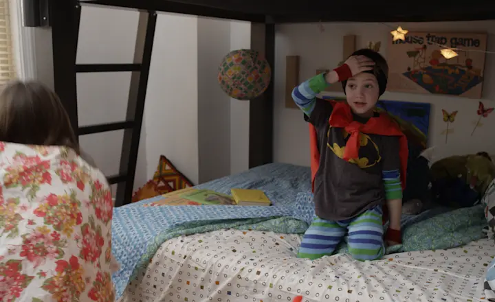 Two young kids playing an adventure game on the bottom bunk of their Adult Bunk Bed from Francis Lofts & Bunks