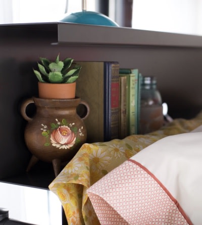 A close up shot of a charcoal bookshelf accessory attached to the top bunk of a Queen Over Queen Adult Bunk Bed.
