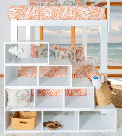 A close up front facing angle of a decorated white staircase accessory attached to a white Queen Over Queen Adult Bunk Bed in a lake house bedroom.