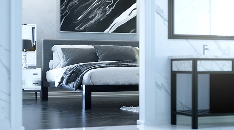 A black metal Alaskan King size platform bed with a gray headboard and various shades of gray bedding in a high end luxury master suite seen only partially from inside the master bathroom.