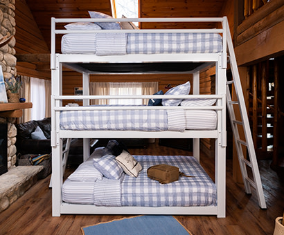 A white queen size Triple Bunk Bed for Adults in a cabin see directly from the right side.