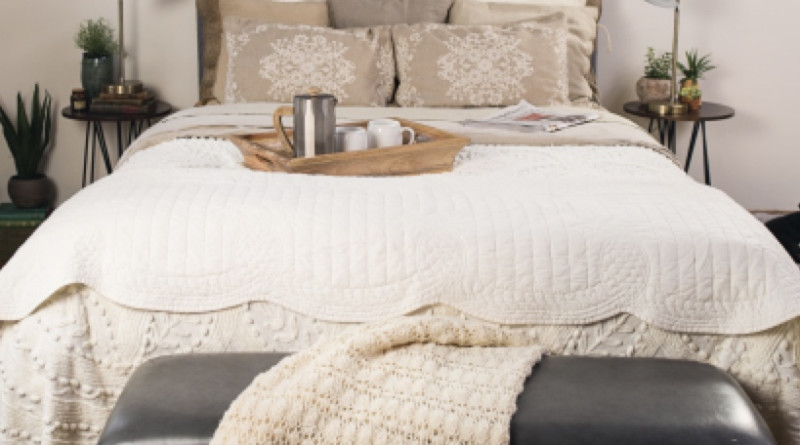 Dressed white Queen Standard Bed with gray fabric headboard seen from the front. Platter with coffee and two mugs sits on the foot of the bed.