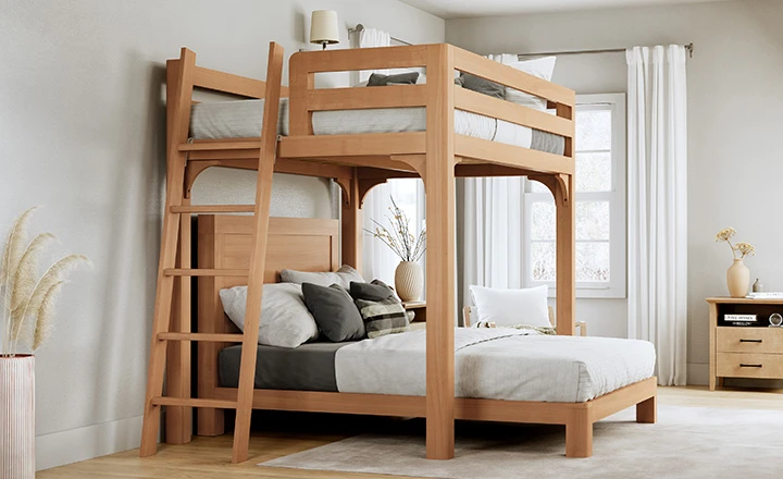 A light-colored Queen Over Queen Wood L-Shaped Bunk Bed for Adults in a nice, upscale guest bedroom with lots of natural light, seen from the foot of the top bunk at a slight angle toward the lower left-hand corner.