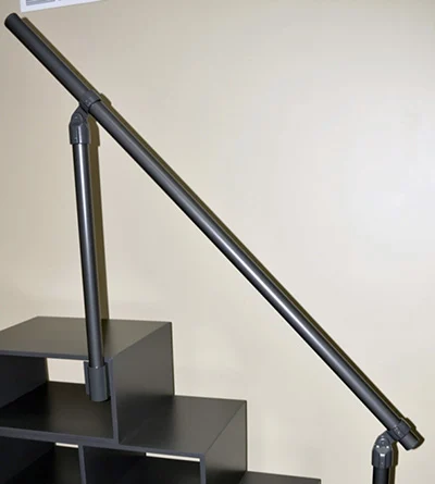 A charcoal aluminum handrail attached to a charcoal wooden staircase for the Francis Lofts & Bunks loft and bunk beds for adults.
