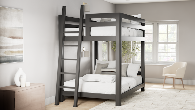 Charcoal queen over queen size Signature Bunk Bed for Adults in a nice, airy, upscale guest room. Has white and light gray bedding on it. Seen from the back and left-hand side of the bed.