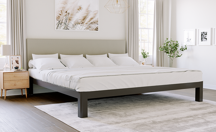 Charcoal Alaskan King bed with light gray headboard in a nice, neutral master bedroom seen from the lower right-hand corner of the bed frame.