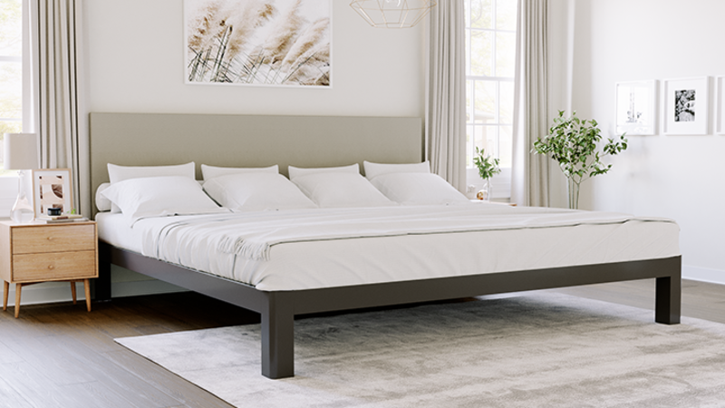 Charcoal Alaskan King bed with light gray headboard in a nice, neutral master bedroom seen from the lower right-hand corner of the bed frame.