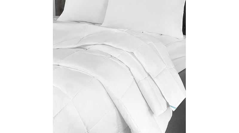 A white duvet insert uncovered laying on a queen size bed with white sheets and white pillowcases.