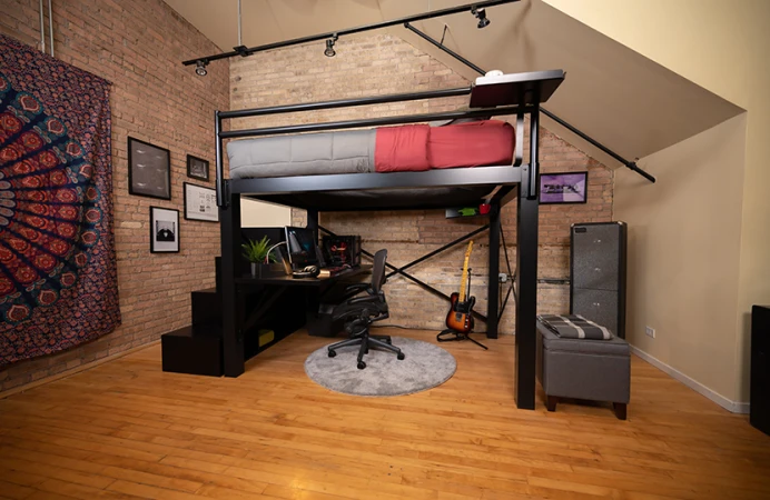 Black queen loft bed for adults with stairs and desk in a nice loft apartment seen from the left-hand side away from the wall at a slight distance.