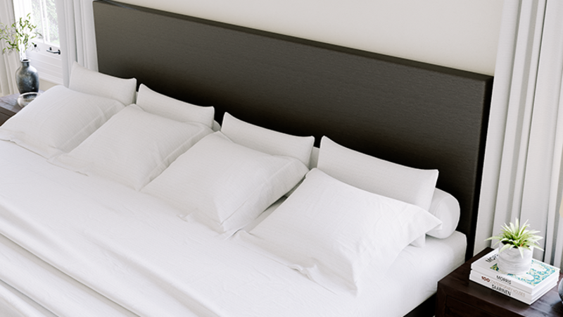 Charcoal Alaskan King Bed with a graphite headboard in a nice, neutral master bedroom seen from a high angle close up on the fabric headboard from the left-hand side of the bed frame.