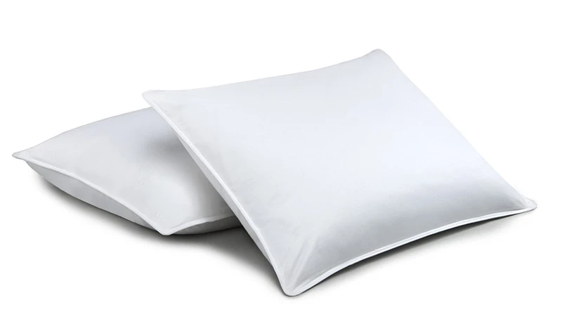 Two white Chamber Down pillows from Standard Textile Home laid one on top of the other on a white background.