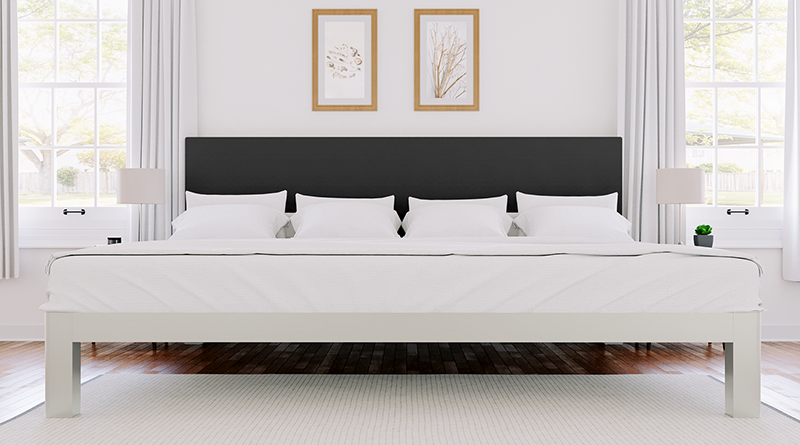 A white Alaskan King size metal Platform Bed with a graphite headboard in an upscale bedroom seen directly from the foot of the bed. 