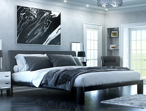 A black Alaskan King size metal Platform Bed with a dark gray headboard in a super luxurious master suite decorated in muted grays, blacks, and whites. Seen here from the lower right-hand corner of the bed frame.
