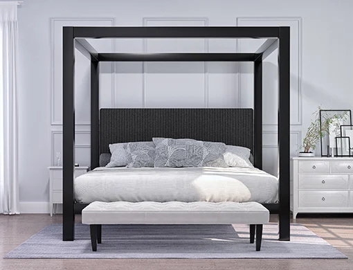 A black Wyoming King size four poster Canopy Bed in a minimalist luxury master bedroom decorated mostly in white and dark colors seen directly from the foot of the bed.