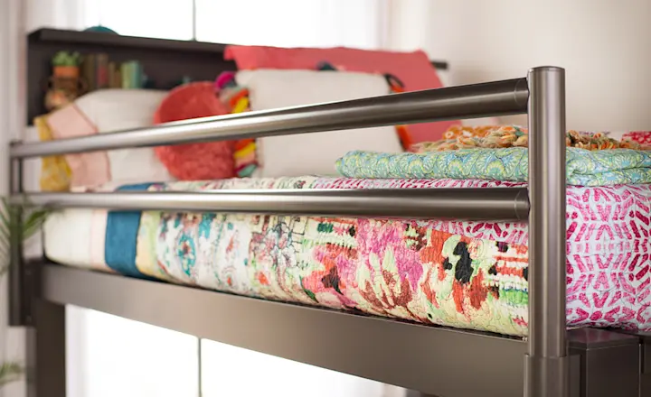 A well made top bunk on a charcoal Queen Over Queen Adult Bunk Bed