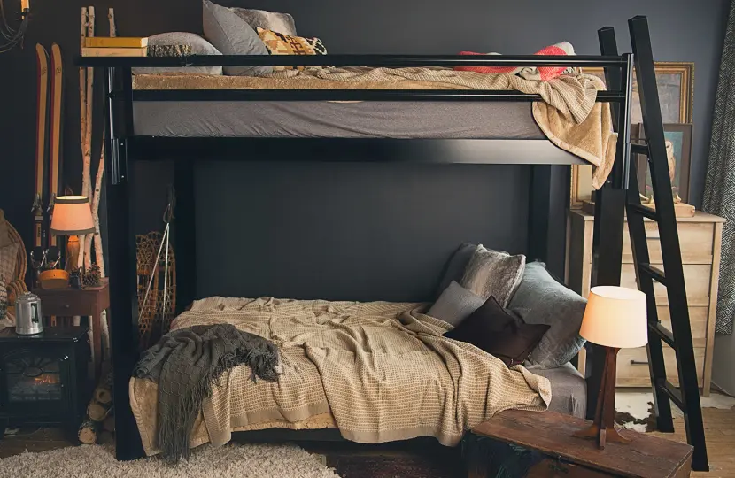 A black Adult Bunk Bed in a ski cabin bedroom seen directly from the left-hand side of the bed.