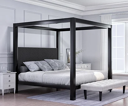 A black Wyoming King size four poster Canopy Bed in a minimalist luxury master bedroom decorated mostly in white and dark colors seen from the lower left-hand corner.