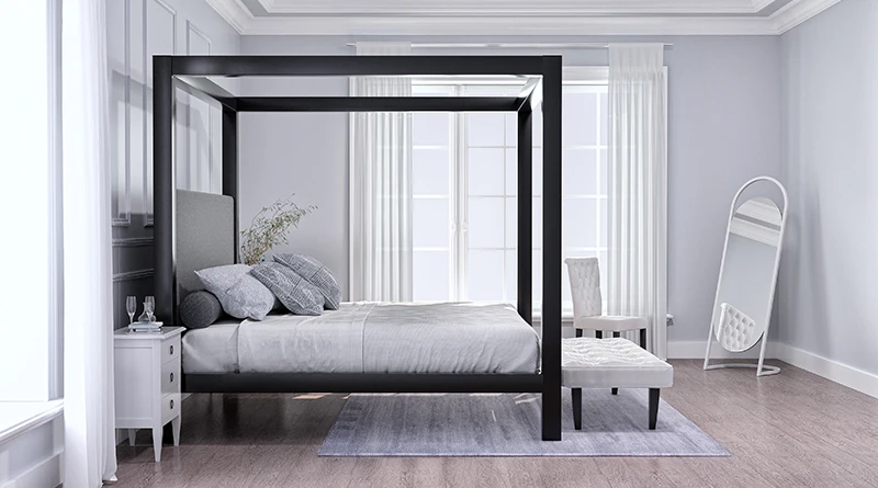 A black Wyoming King size metal four poster Canopy Bed in a minimalist, sparsely designed upscale master bedroom decorated mostly in white and light colors. Seen directly from the right-hand side of the bed at a slight distance.