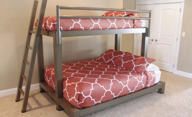 A bronze Twin Over Queen Adult Bunk Bed with red bedding. 