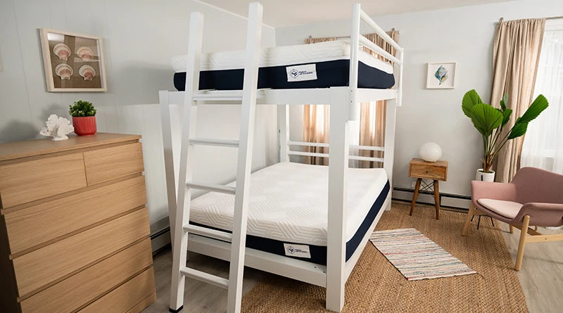 A white Queen Over Queen Adult Bunk Bed with two undressed Francis Lofts and Bunks mattresses