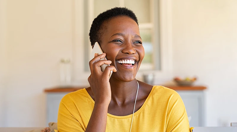 A middle-aged woman talking on her cell phone and smiling.