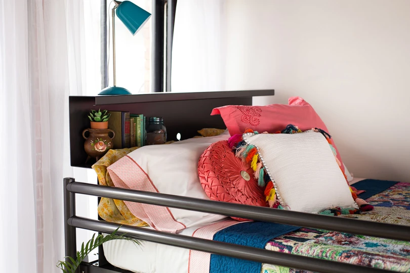 A charcoal Adult Bunk Bed in a fun young adult bedroom decorated with vintage furniture. Seen at a close up of the bookshelf headboard.
