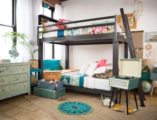 Distant side angle view of a charcoal Queen Over Queen Adult Bunk Bed shared by two female roommates