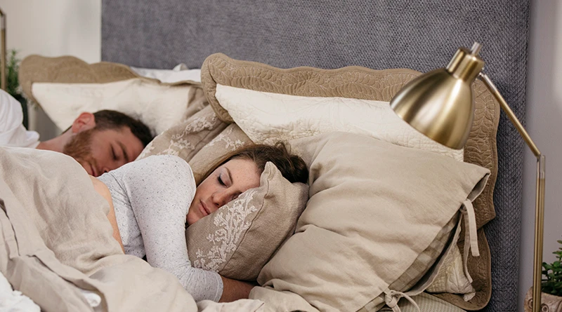 Couple sleeping on a Platform Bed from AdultBunkBeds.com with the camera focused on the young woman from the left-hand side of the bed.