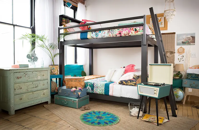 A charcoal Adult Bunk Bed in a fun young adult bedroom decorated with vintage furniture. Seen from the right-hand side of the bed at a slight angle toward the foot of the bed.