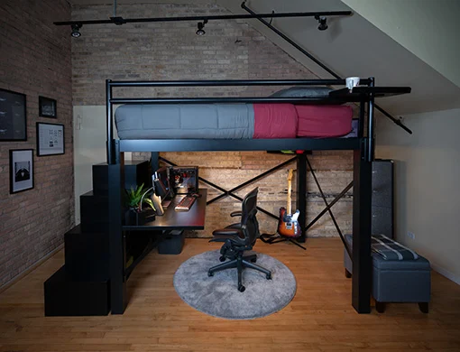 A black Queen Loft Bed in a young adult gamer's bedroom