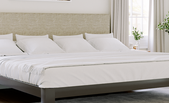 Charcoal Alaskan King size metal platform bed with an Oatmeal headboard in an understated but elegant and upscale neutral master bedroom. Seen here from the corner of the lower right-hand side of the bed.