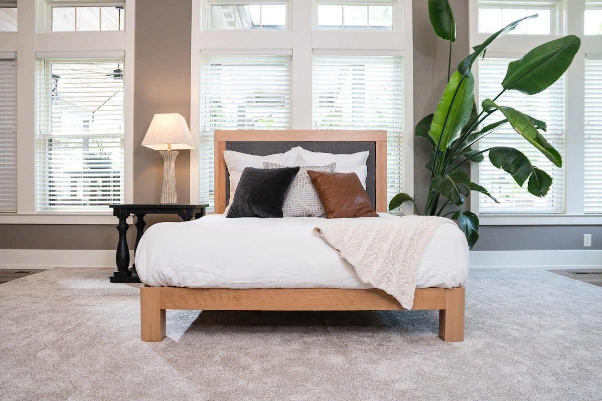 Wood platform bed with layered pillows and bedding