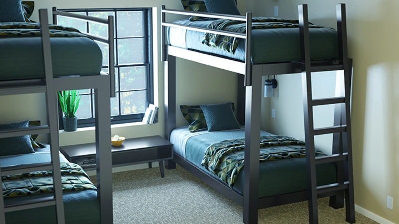 Two Charcoal Adult Bunk Beds in a sparsely decorated guest bedroom side-by-side seen at a close, high angle with the left-side bed slightly out of frame and focused on the lower left-hand corner of the right-side bed.
